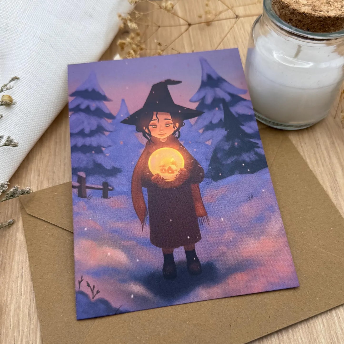 Zauberhafte Postkarte „Hexe mit leuchtender Schneekugel“ – Winter Illustration